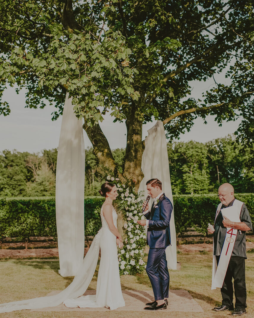 A couple reading their vows in a vineyard at The Hare Wine Co. in Niagara-on-the-Lake.