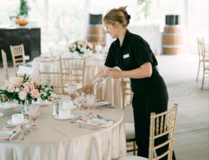 An event caterer setting the table at Bella Terra Vineyards.