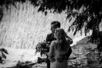 A couple embracing by the Millcroft Inn & Spa waterfall in Caledon, Ontario.