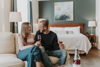 A couple relaxing with a glass of wine in their suite at the Inn On The Twenty hotel in Jordan Village.