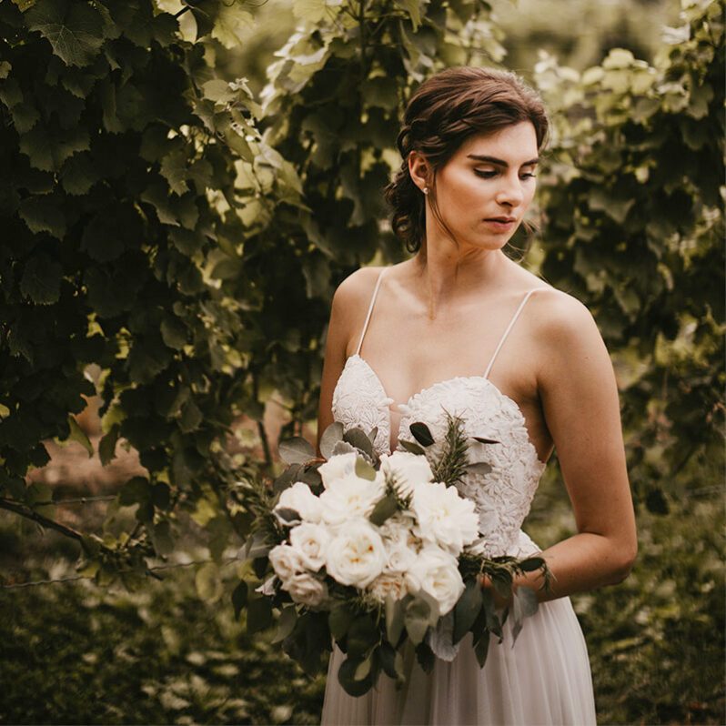 Bride in garden on wedding day at Inn On The Twenty in Jordan Village