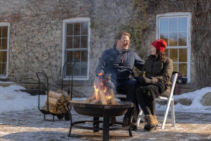 A couple sitting by the fire at Millcroft Inn & Spa.