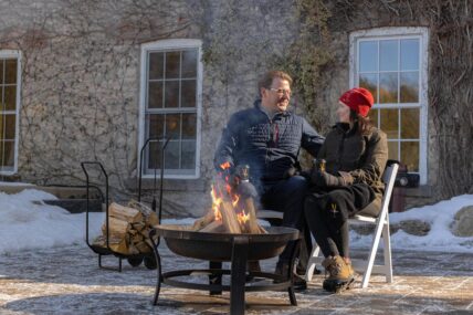 A couple sitting by a fire at Millcroft Inn & Spa in Caledon, Ontario.
