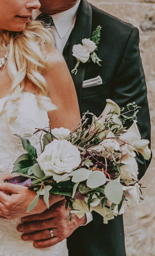 A bride carrying a floral arrangement at Millcroft Inn & Spa in Caledon, Ontario.