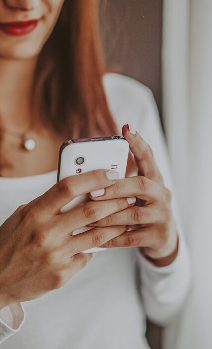 Woman holding a smartphone using Wi-Fi at Moffat Inn in Niagara on the Lake