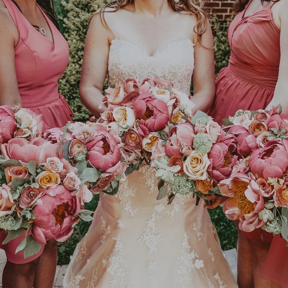 Bride and bridesmaids holding a wedding flower bouquet at a Vintage Hotels location.
