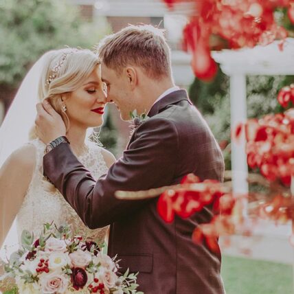 A newly married couple embracing in The Gardens at Pillar and Post in Niagara-on-the-Lake.