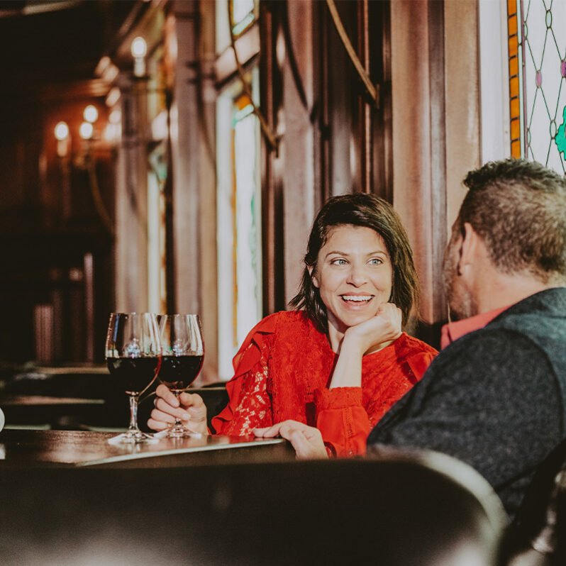Couple indulging in a glass of wine during dinner at Bacchus Restaurant.