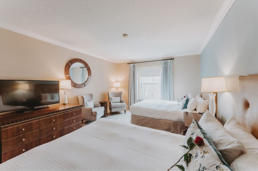 Two beds and seating area in a Traditional Guest Room Bed at the Queen's Landing hotel in Niagara-on-the-Lake.