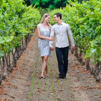 A couple walking through vineyards in Jordan, Ontatio.