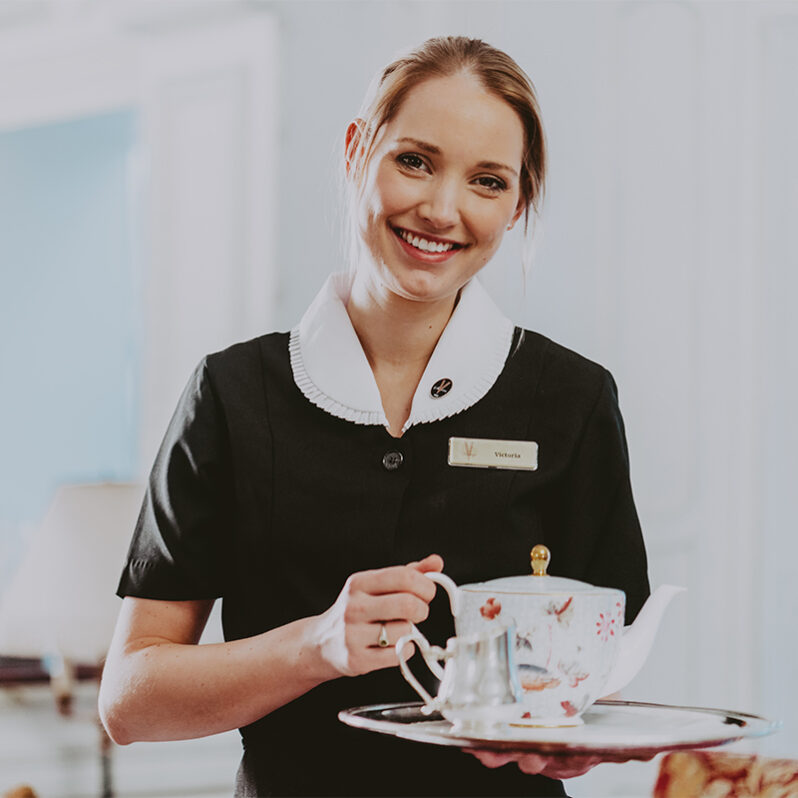 Staff member at Vintage Hotels serving afternoon tea