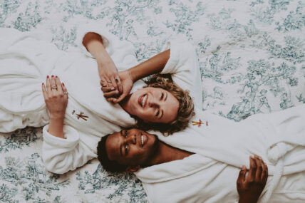 Couple laying on a bed in the Guest Suite at Prince of Wales in Niagara-on-the-Lake